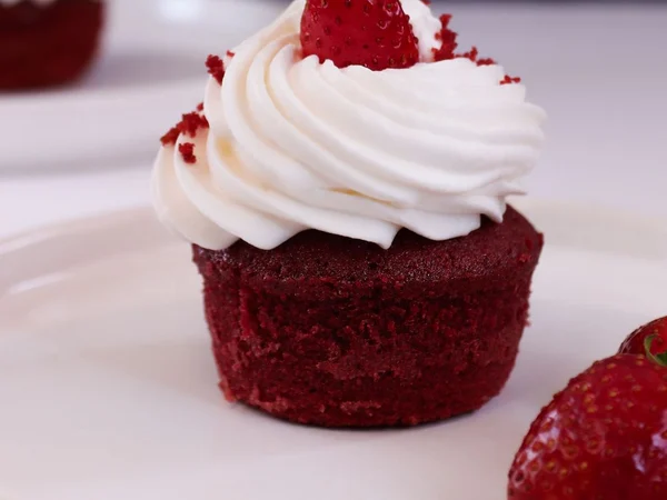 Red velvet cupcakes with deep red cake and pale frosting
